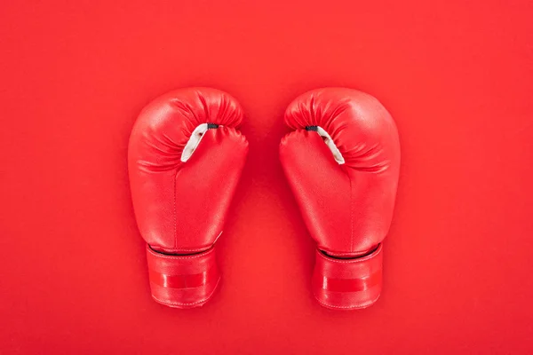 Вид зверху на пару шкіряних боксерських рукавичок ізольовано на червоному — стокове фото