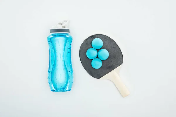 Vue du dessus de la bouteille de sport bleue près des balles de ping-pong et des raquettes isolées sur blanc — Photo de stock