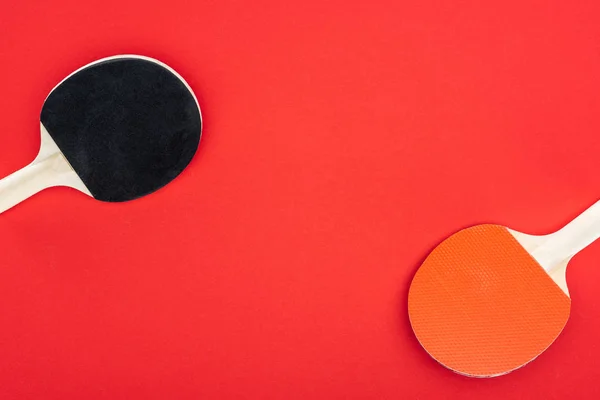 Vue du dessus des raquettes de ping pong isolées sur rouge — Photo de stock