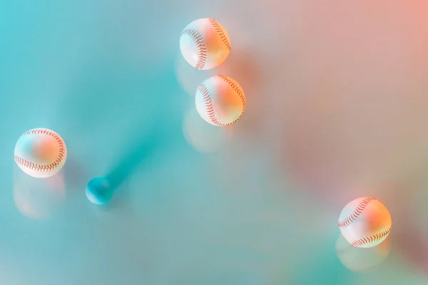 Motion blue of white and leather softballs near ping pong ball on pink and blue — Stock Photo