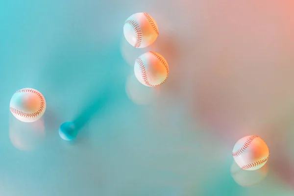 Mouvement bleu de balles de softball blanches et en cuir près de balle de ping-pong sur rose et bleu — Photo de stock