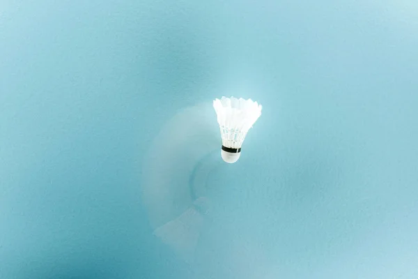 Motion blur of white shuttlecock with feathers on blue — Stock Photo