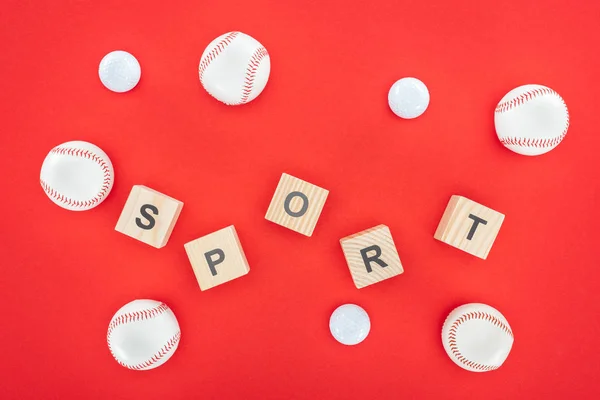 Sport letters on wooden cubes near softballs isolated on red — Stock Photo