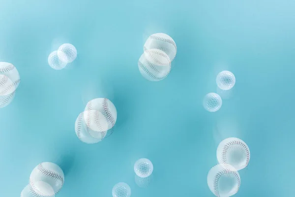 Motion blue of white and leather softballs on blue — Stock Photo