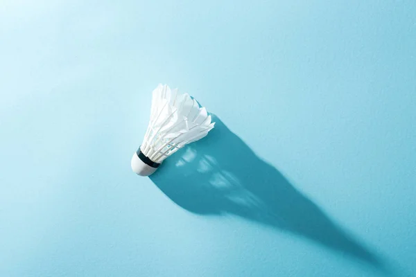 Top view of white shuttlecock with feathers on blue — Stock Photo