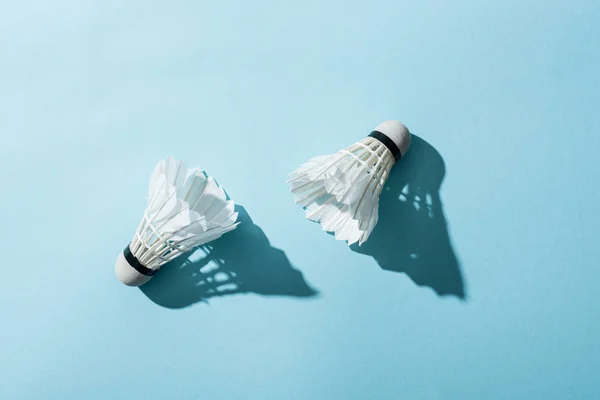 Top view of white shuttlecocks with feathers on blue — Stock Photo