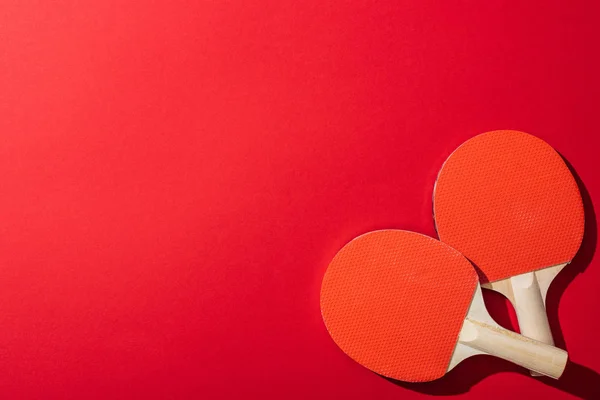 Vista superior de raquetes de tênis de mesa isolados em vermelho — Fotografia de Stock