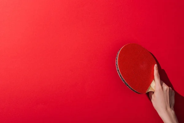 Обрезанный вид женщины проведение настольный теннис ракетка на красный — стоковое фото