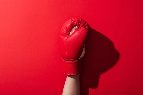 Cropped view of woman in leather boxing glove on red — Stock Photo