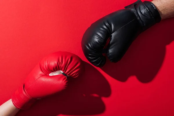 Cropped view of man and woman in leather boxing gloves on red — Stock Photo