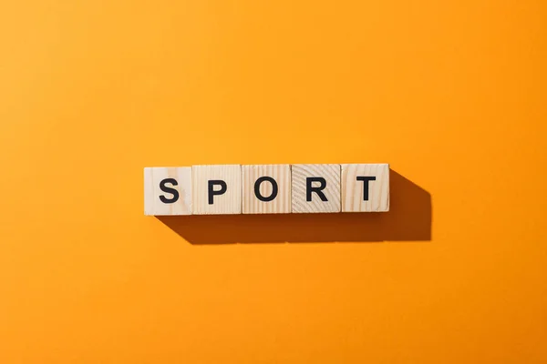 Top view of wooden cubes with sport lettering on yellow — Stock Photo