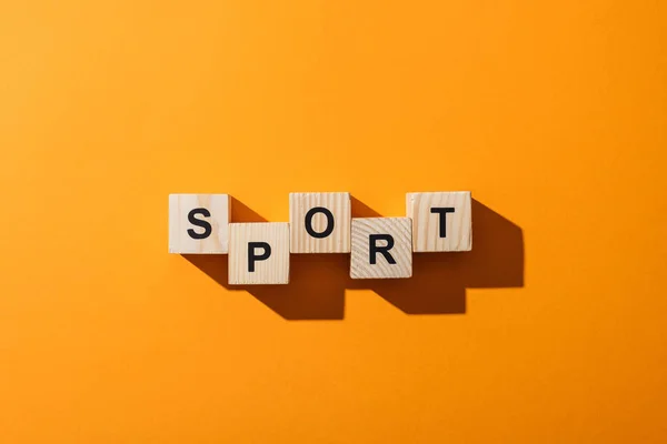 Top view of wooden blocks with sport lettering on yellow — Stock Photo