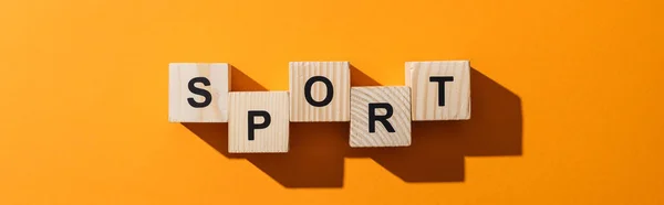 Panoramic shot of wooden blocks with sport lettering on yellow — Stock Photo