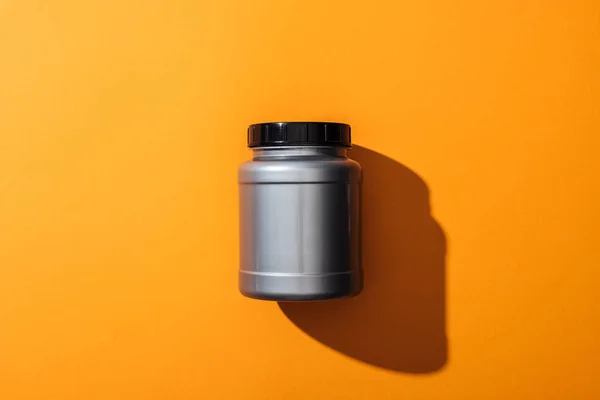 Top view of grey plastic jar with protein on yellow — Stock Photo