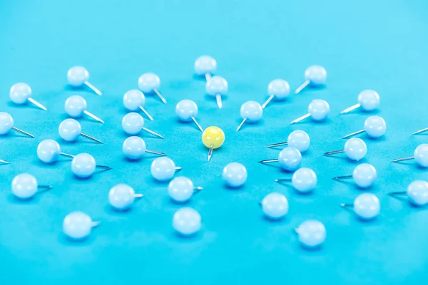 Gelbe Büroklammer abgerundet durch blaue Büroklammern auf blauem Hintergrund, Gewaltkonzept — Stockfoto