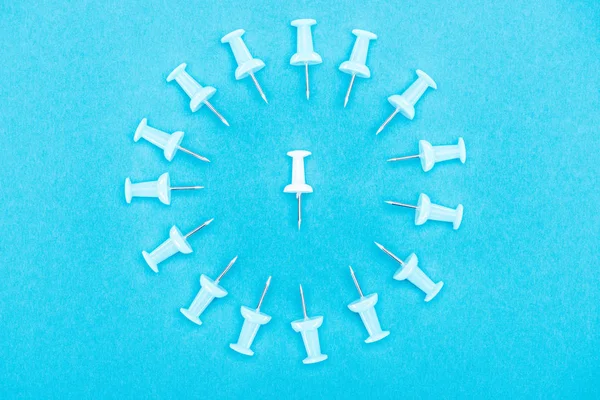 Top view of blue paper clips with white paper clip in middle isolated on blue, violence concept — Stock Photo