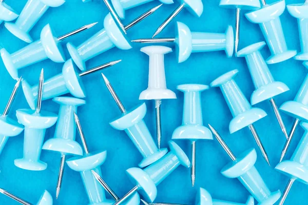 Top view of white paper clip in pile of blue paper clips, violence concept — Stock Photo