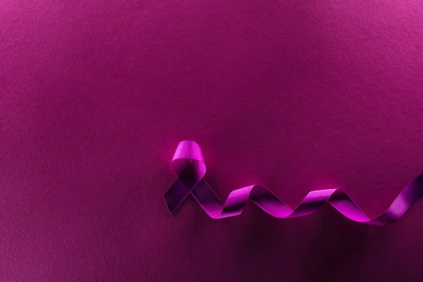 Top view of purple ribbon on purple background in shadow — Stock Photo