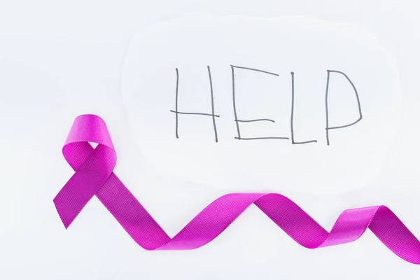 Top view of purple ribbon near paper with inscription help isolated on white — Stock Photo