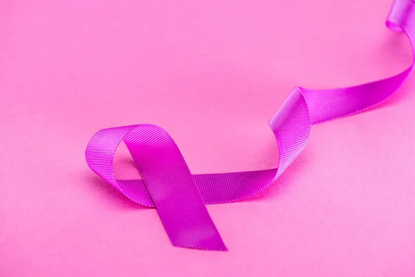 Purple ribbon on pink background, violence concept — Stock Photo