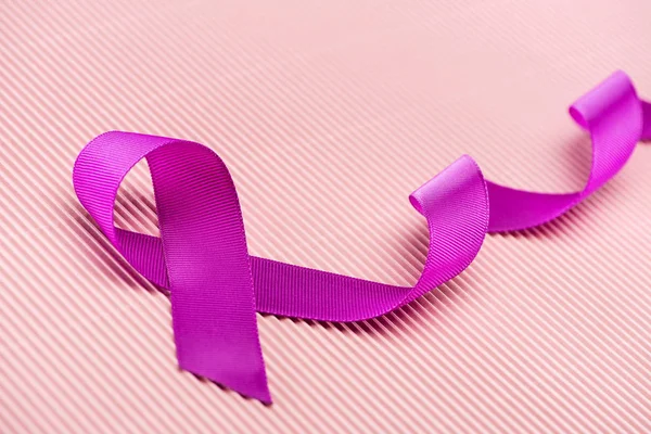 Purple ribbon on pink background, violence concept — Stock Photo