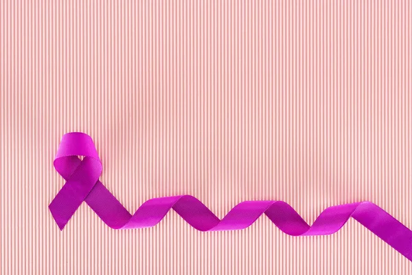 Top view of purple ribbon on pink texture background — Stock Photo