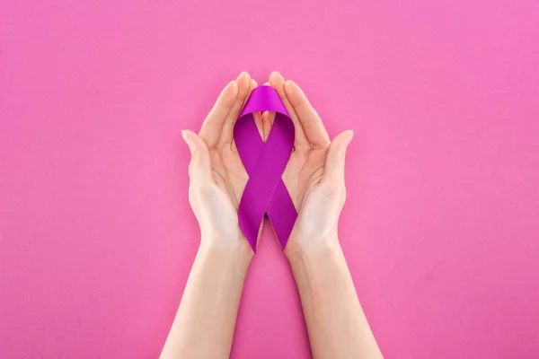 Cropped view of woman holding purple ribbon means violence isolated on pink — Stock Photo