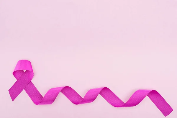 Вид сверху на длинную фиолетовую полосу на светло-розовом фоне — стоковое фото