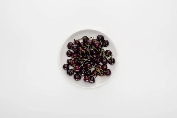 Vista superior de cerezas rojas y maduras en plato blanco - foto de stock