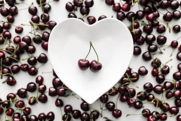 Vue de dessus des cerises mûres, fraîches et douces sur plaque blanche — Photo de stock