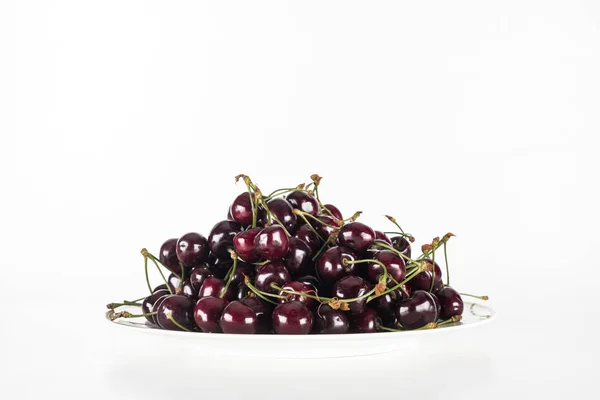 Red, fresh and sweet cherries on plate on white background with copy space — Stock Photo