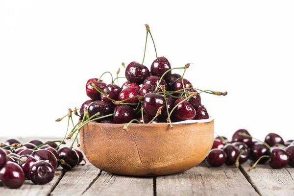 Красные, свежие, цельные и спелые вишни, покрытые капельками на чаше на деревянном столе — стоковое фото