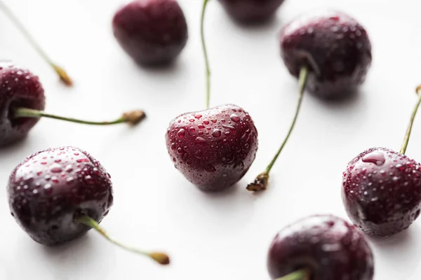 Selective focus of red, whole and ripe cherries covered with water drops — Stock Photo