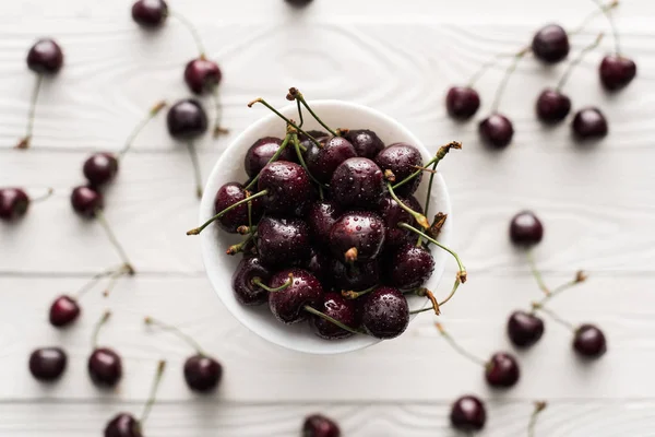 Top view of fresh, sweet and ripe cherries covered with water drops on bowl — Stock Photo