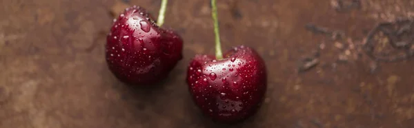 Panoramic shot of fresh, sweet, red and ripe cherries with droplets on stoned background — Stock Photo