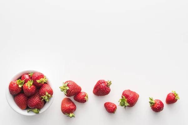 Vista dall'alto di fragole dolci e intere su ciotola su sfondo bianco — Foto stock