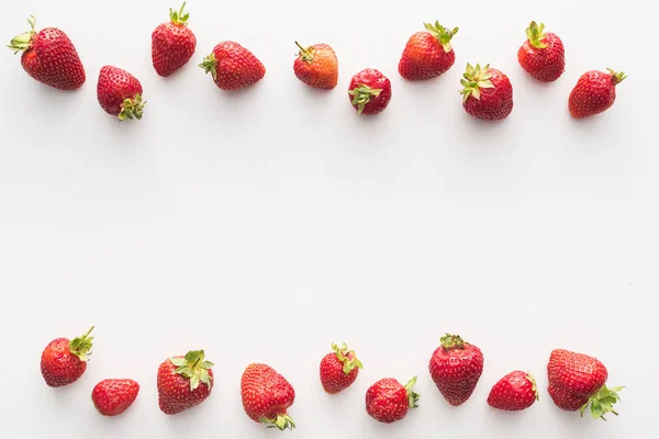 Vue de dessus des fraises douces et rouges sur fond blanc — Photo de stock