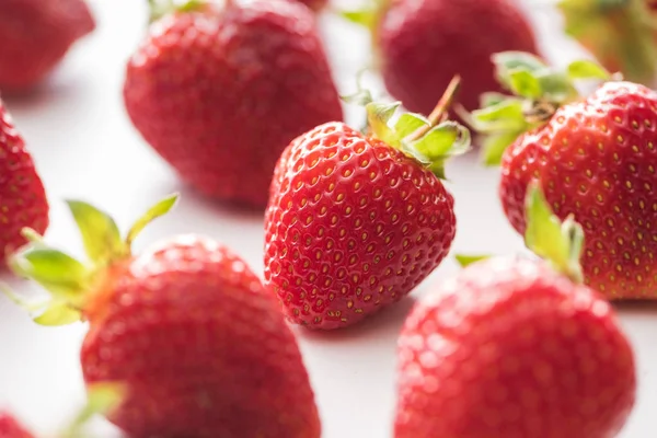 Enfoque selectivo de fresas maduras y dulces sobre fondo blanco - foto de stock