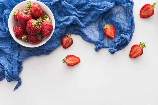 Vista dall'alto di fragole dolci e rosse sulla ciotola con panno blu — Foto stock