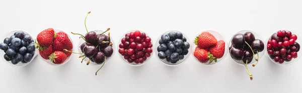 Panoramaaufnahme von frischen und reifen Erdbeeren, Blaubeeren, Kirschen und Preiselbeeren in Plastikbechern — Stockfoto