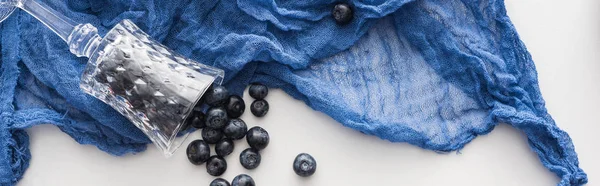 Panoramic shot of fresh and sweet blueberries, wine glass with blue cloth — Stock Photo