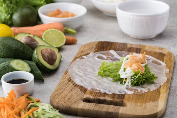 Salat, Nudeln und Garnelen auf Reispapier, auf Schneidebrett — Stockfoto