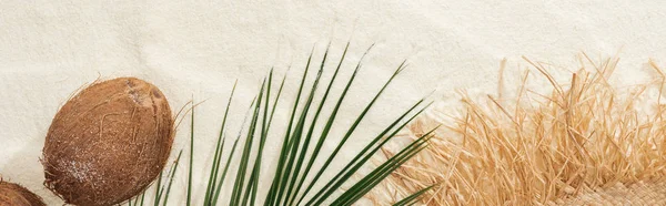 Vue du dessus de la feuille de palmier, noix de coco et chapeau de paille sur sable, vue panoramique — Photo de stock