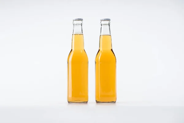 Garrafas de vidro de cerveja em linha no fundo branco — Fotografia de Stock