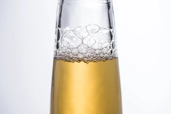 Vista de perto da garrafa de cerveja com bolhas isoladas em branco — Fotografia de Stock