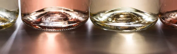 Close up view of bottles with rose and white wine and back light, panoramic shot — Stock Photo