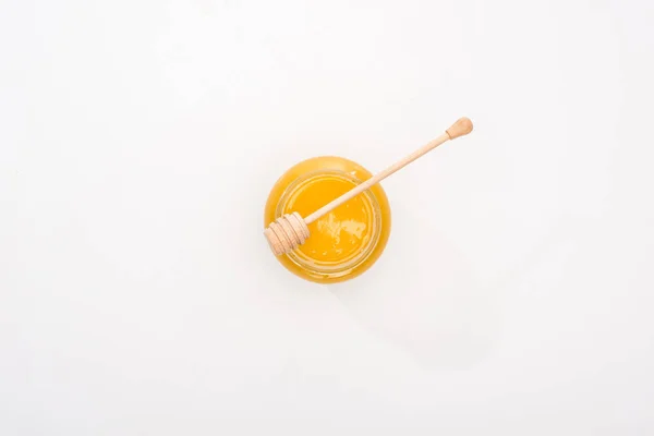 Top view of jar with honey and wooden honey dipper on white background — Stock Photo