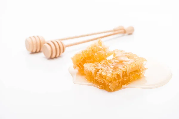 Honeycomb with honey and wooden honey dippers on white background — Stock Photo