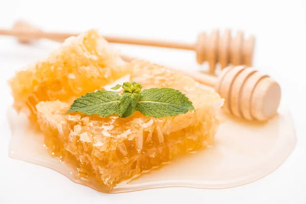 Favo de mel com hortelã e mel perto de mergulhadores de mel de madeira isolados em branco — Fotografia de Stock