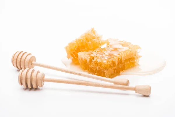 Nid d'abeille avec du miel près des trempettes en bois sur fond blanc — Photo de stock